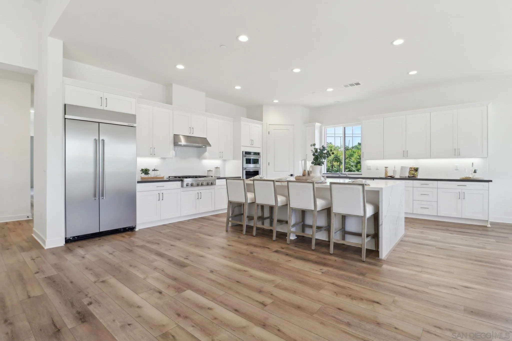 2745 Alexander Drive Escondido, CA 92029 - Photo 6 of 39 a kitchen with stainless steel appliances a dining table chairs and wooden floor