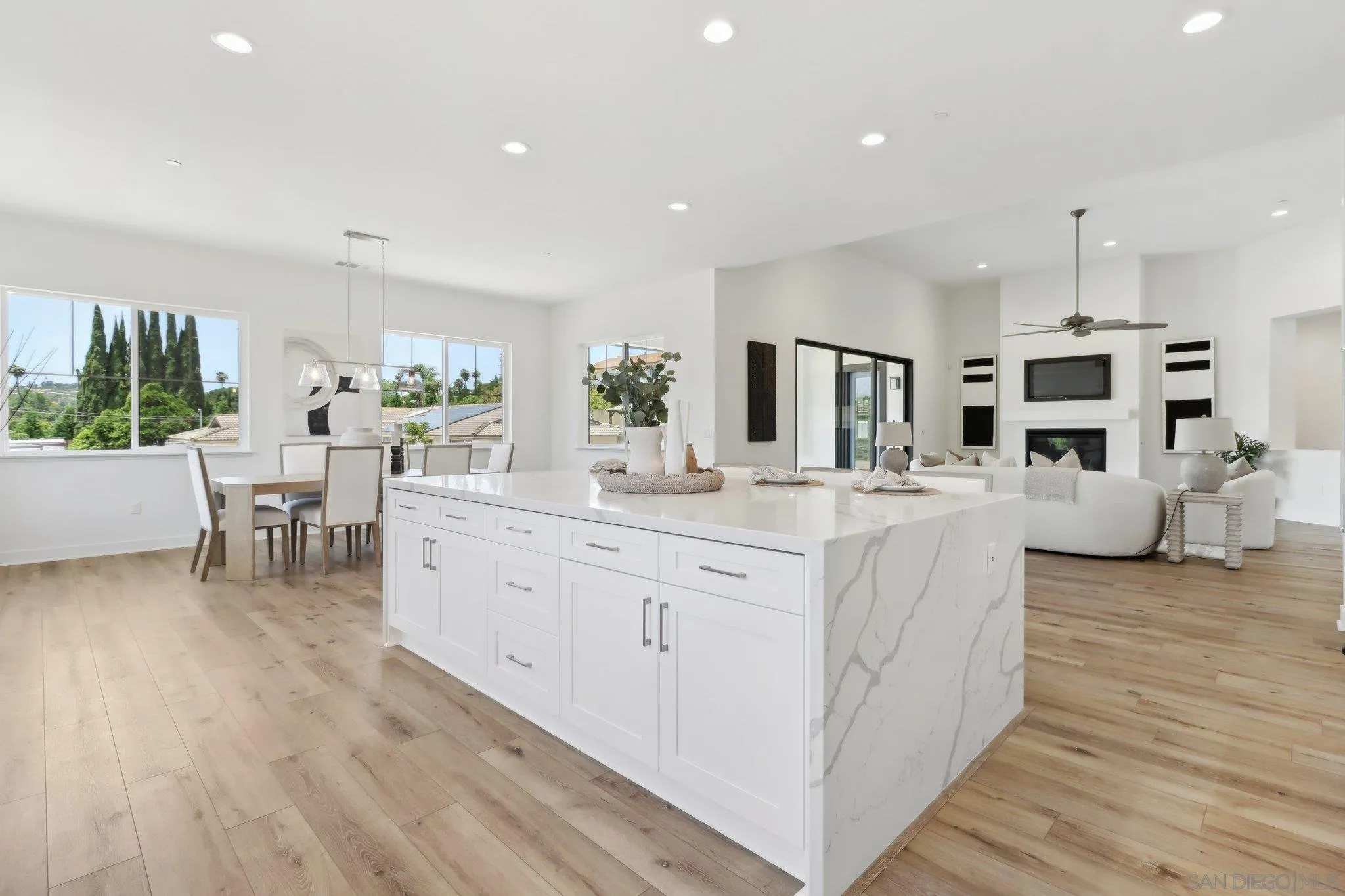 2745 Alexander Drive Escondido, CA 92029 - Photo 10 of 39 a large room with kitchen island a sink dishwasher a dining table and chairs with wooden floor
