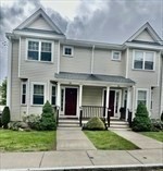 a front view of a house with a yard and potted plants