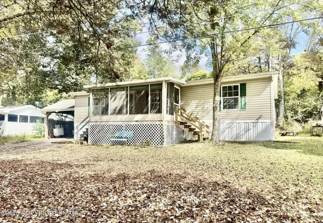 a view of a house with a big yard and large tree