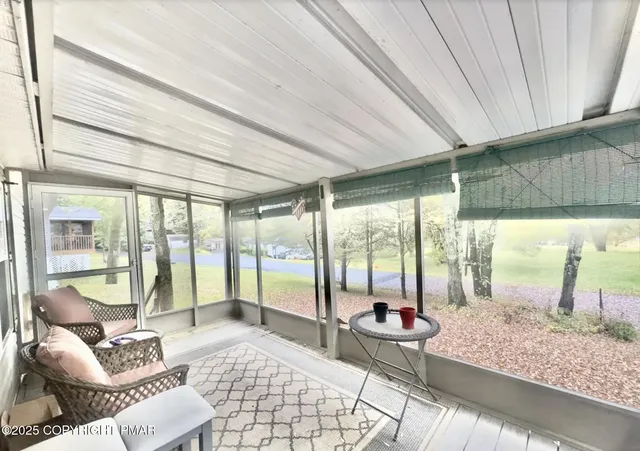 a living room with furniture and a floor to ceiling window