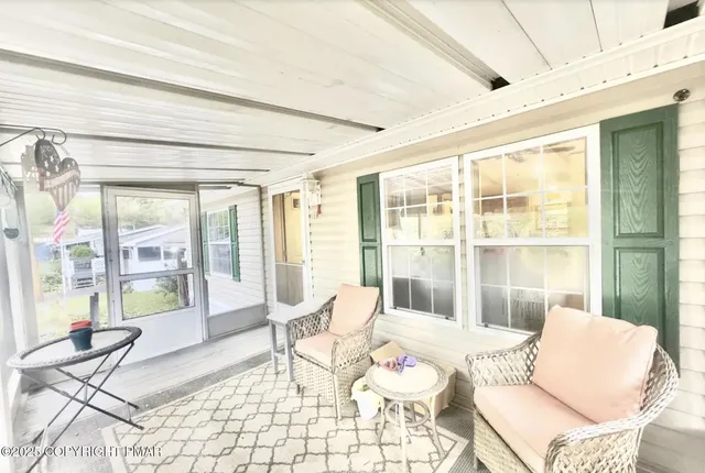 a living room with furniture and floor to ceiling windows