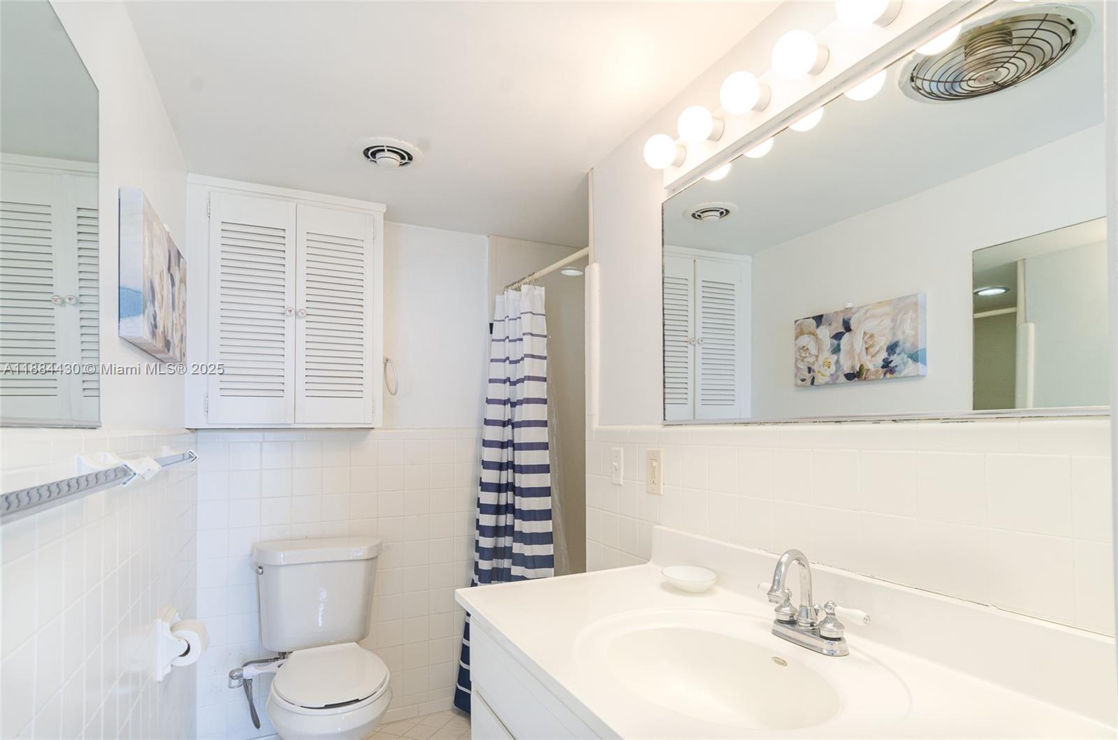 1470 South Ocean Boulevard, Unit 702 Pompano Beach, FL 33062 - Photo 13 of 15 a bathroom with a sink a toilet and a mirror