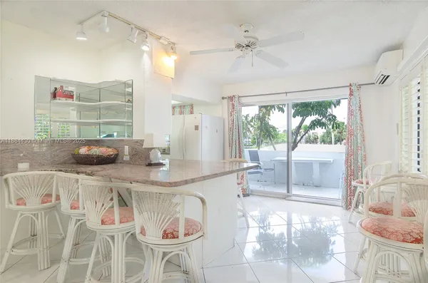 a kitchen with stainless steel appliances granite countertop a table and chairs in it