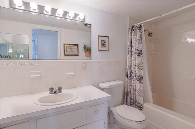 a bathroom with a sink a toilet a mirror a vanity and shower