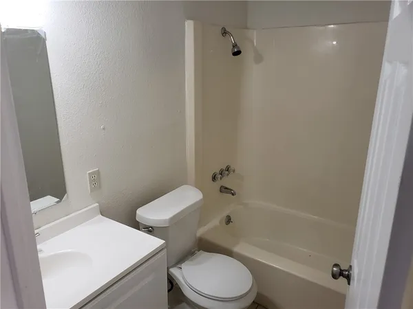a white toilet sitting next to a bath tub