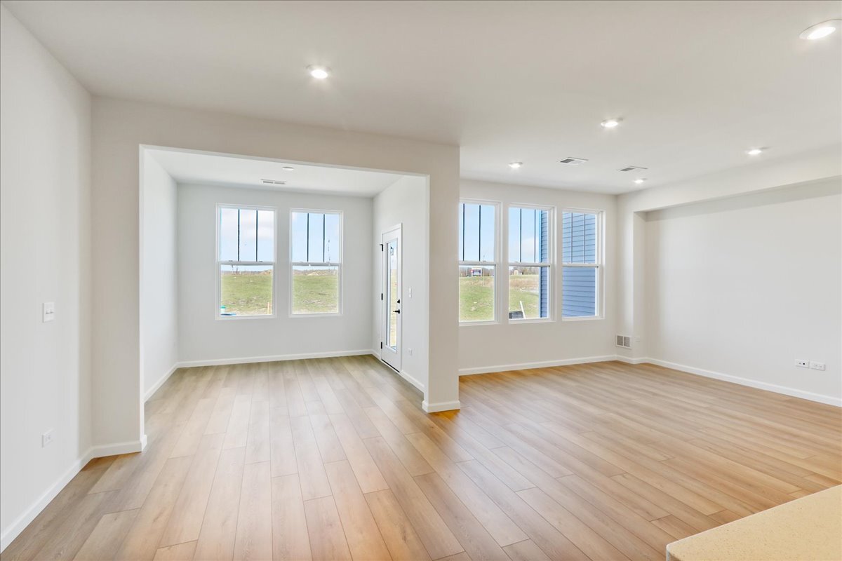 692 Switchgrass Way, Unit 57004 Bolingbrook, IL 60490 - Photo 14 of 25 an empty room with wooden floor and windows