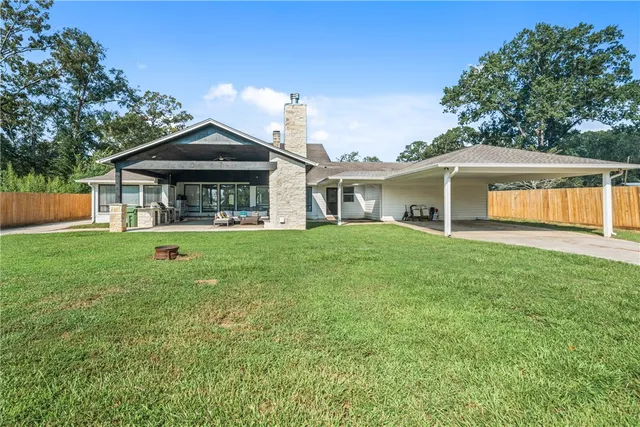 a front view of a house with a yard and trees