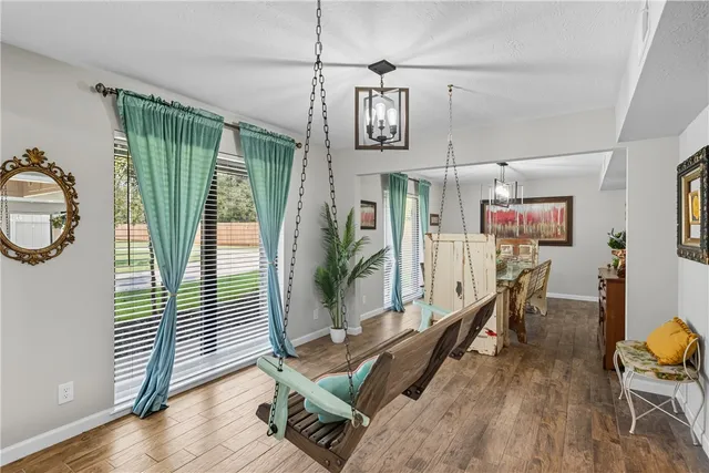 a kitchen with stainless steel appliances granite countertop a sink a stove a refrigerator cabinets and chairs