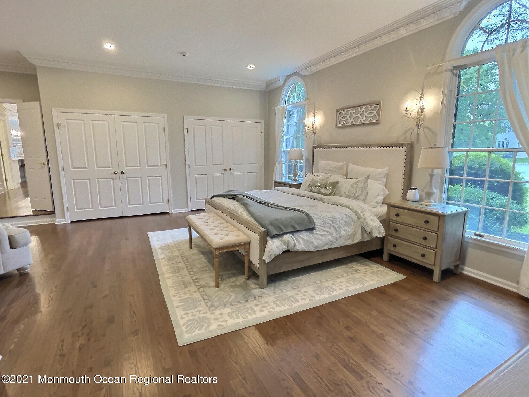 21 Dearborn Drive Holmdel, NJ 07733 - Photo 14 of 48 a spacious bedroom with a bed a table and large mirror