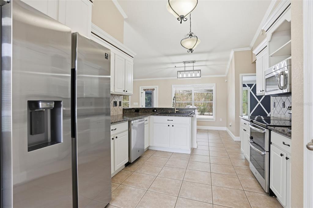 26 Statice Court Homosassa, FL 34446 - Photo 14 of 70 a kitchen with stainless steel appliances granite countertop a refrigerator and a stove top oven