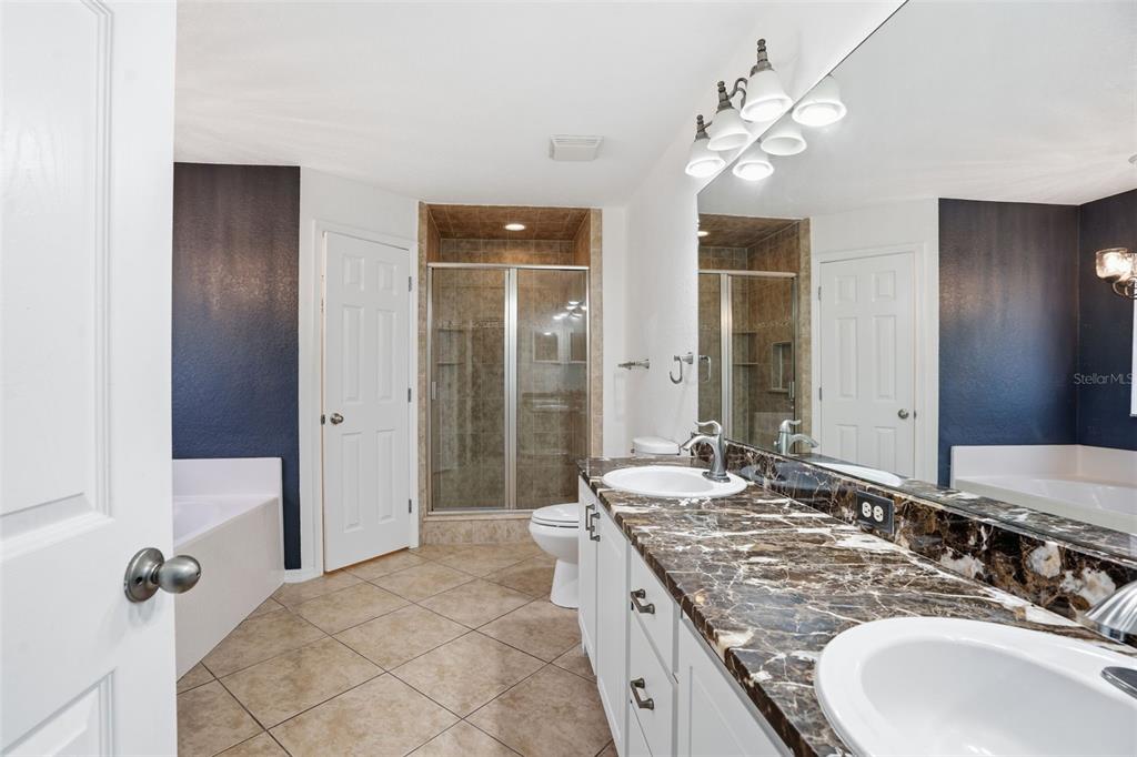 26 Statice Court Homosassa, FL 34446 - Photo 32 of 70 a bathroom with a granite countertop sink a mirror and a shower