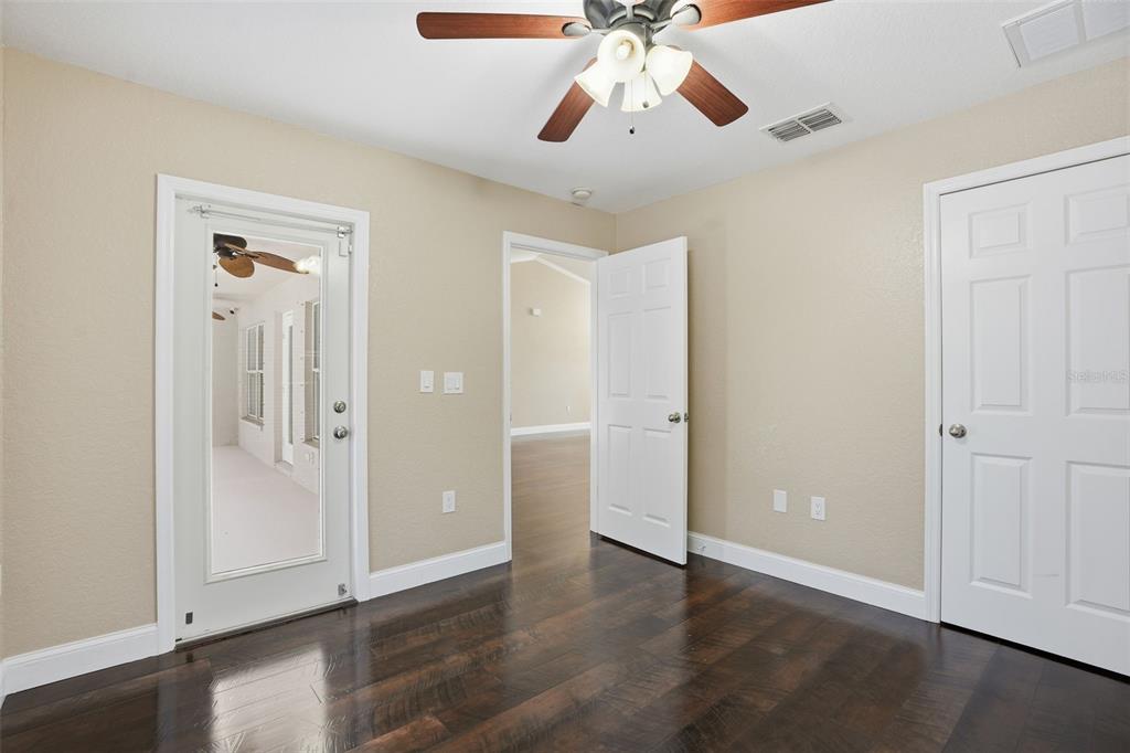 26 Statice Court Homosassa, FL 34446 - Photo 36 of 70 an empty room with wooden floor chandelier fan and closet area