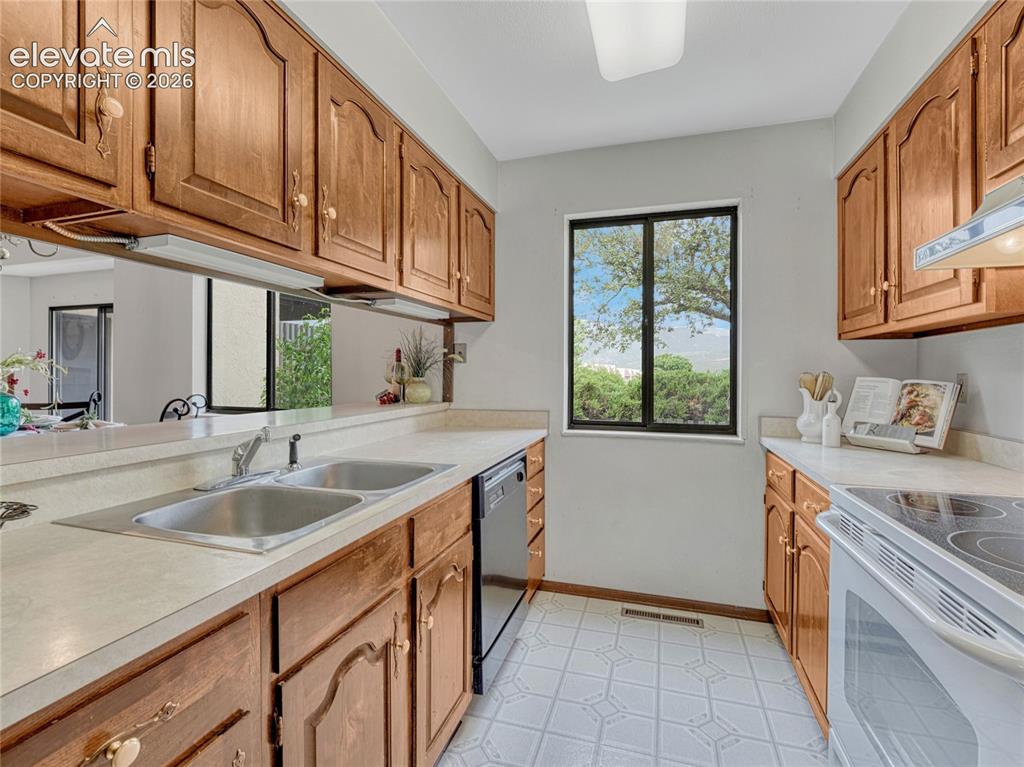 1146 Fontmore Road, Unit A Colorado Springs, CO 80904 - Photo 17 of 24 a kitchen with stainless steel appliances granite countertop a sink stove and cabinets