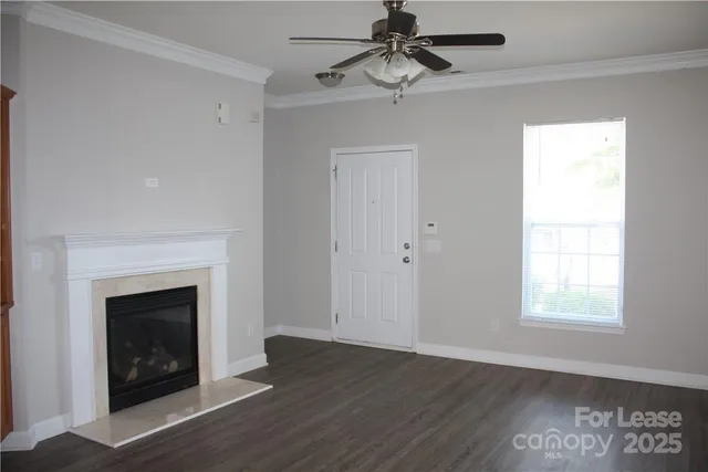 an empty room with wooden floor a fireplace and window
