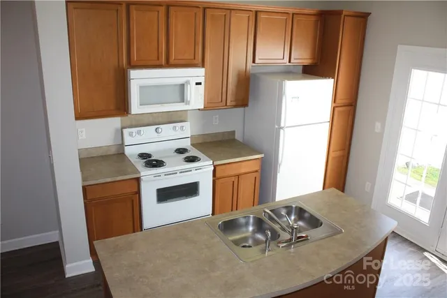 a kitchen with a stove a sink dishwasher and a refrigerator