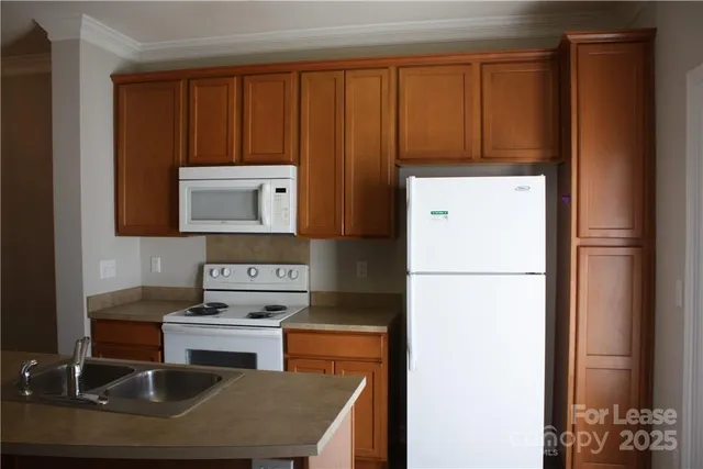 a kitchen with stainless steel appliances granite countertop a refrigerator sink and stove