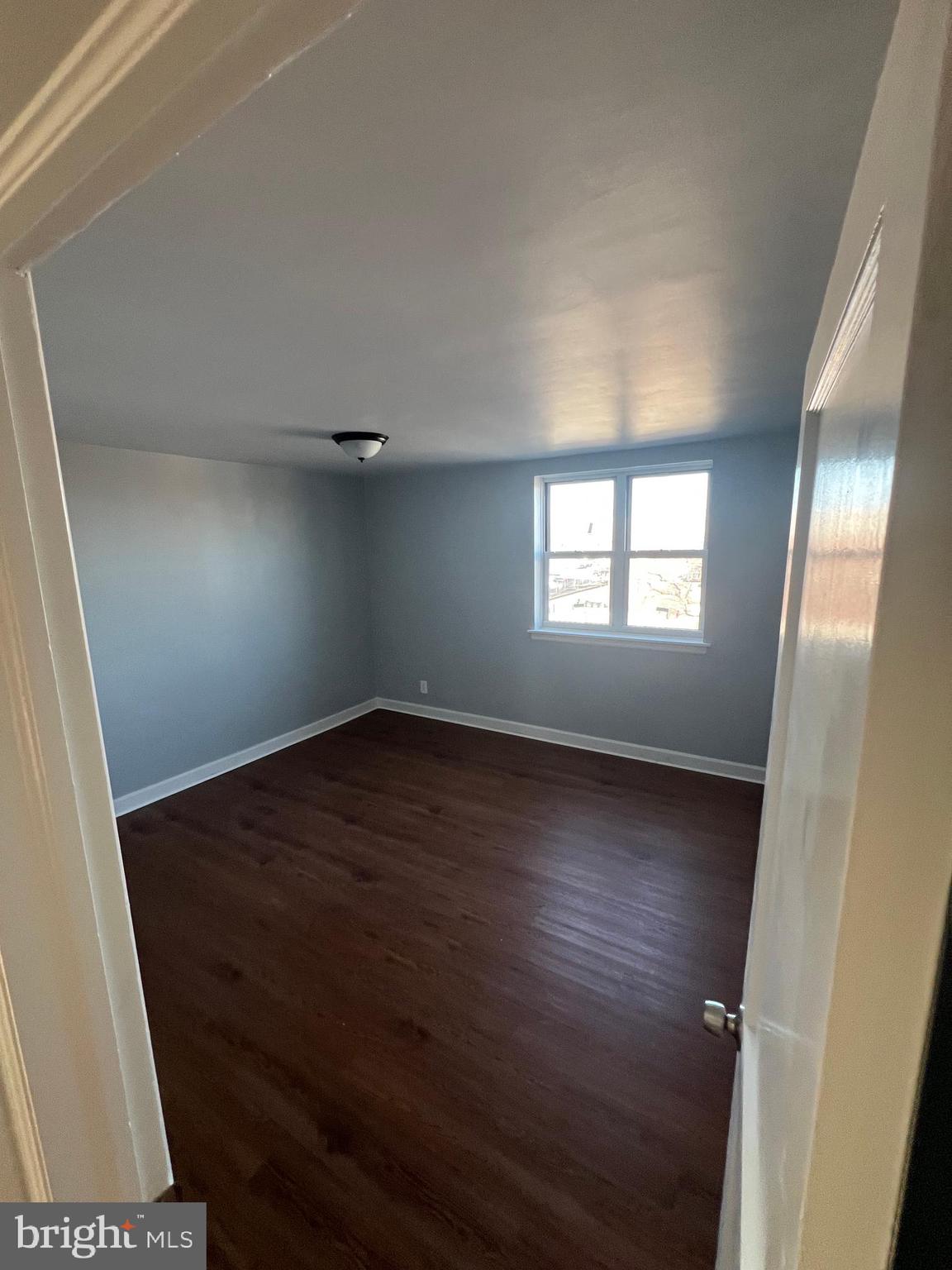 2056 Robbins Street Philadelphia, PA 19149 - Photo 2 of 9 an empty room with wooden floor and windows