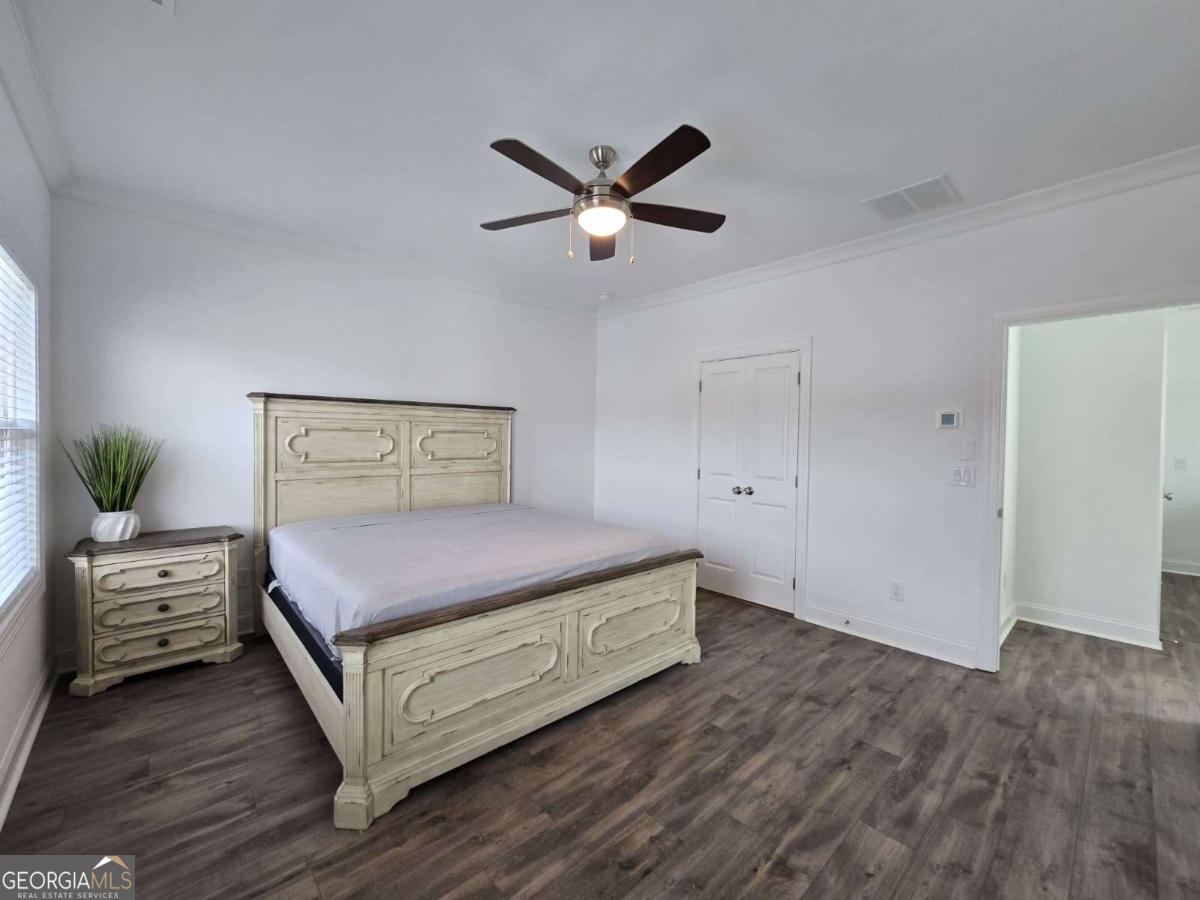 825 Green Sapling Trail, Unit 18 Suwanee, GA 30024 - Photo 27 of 44 a bedroom with a bed and a chandelier