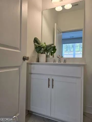 a view of an empty room with wooden floor and windows