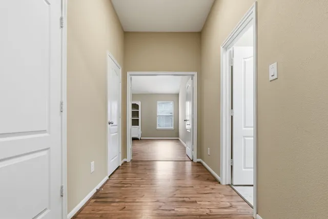 a view of a hallway with wooden floor