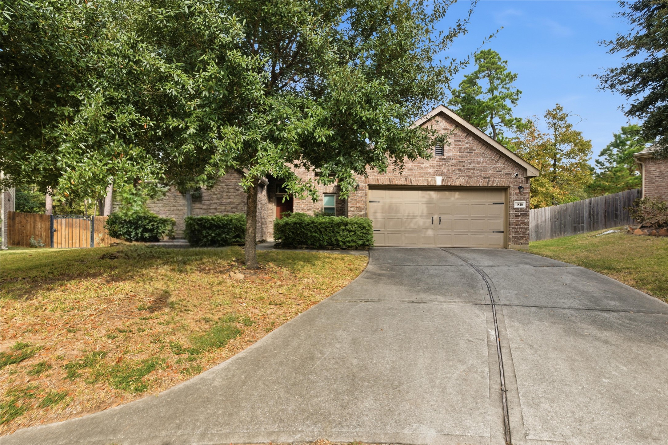 1810 Nantz Lane Conroe, TX 77304 - Photo 2 of 23 a view of a white house next to a yard with large trees