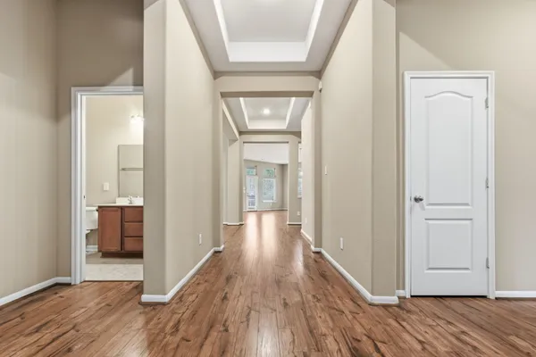 a view of a hallway with wooden floor and closet