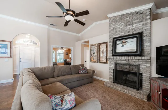 a living room with furniture a fireplace and a flat screen tv