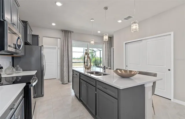 a kitchen with kitchen island a refrigerator and a dining table