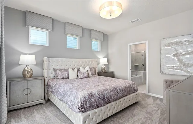 a bedroom with a bed a mirror on dresser and a window