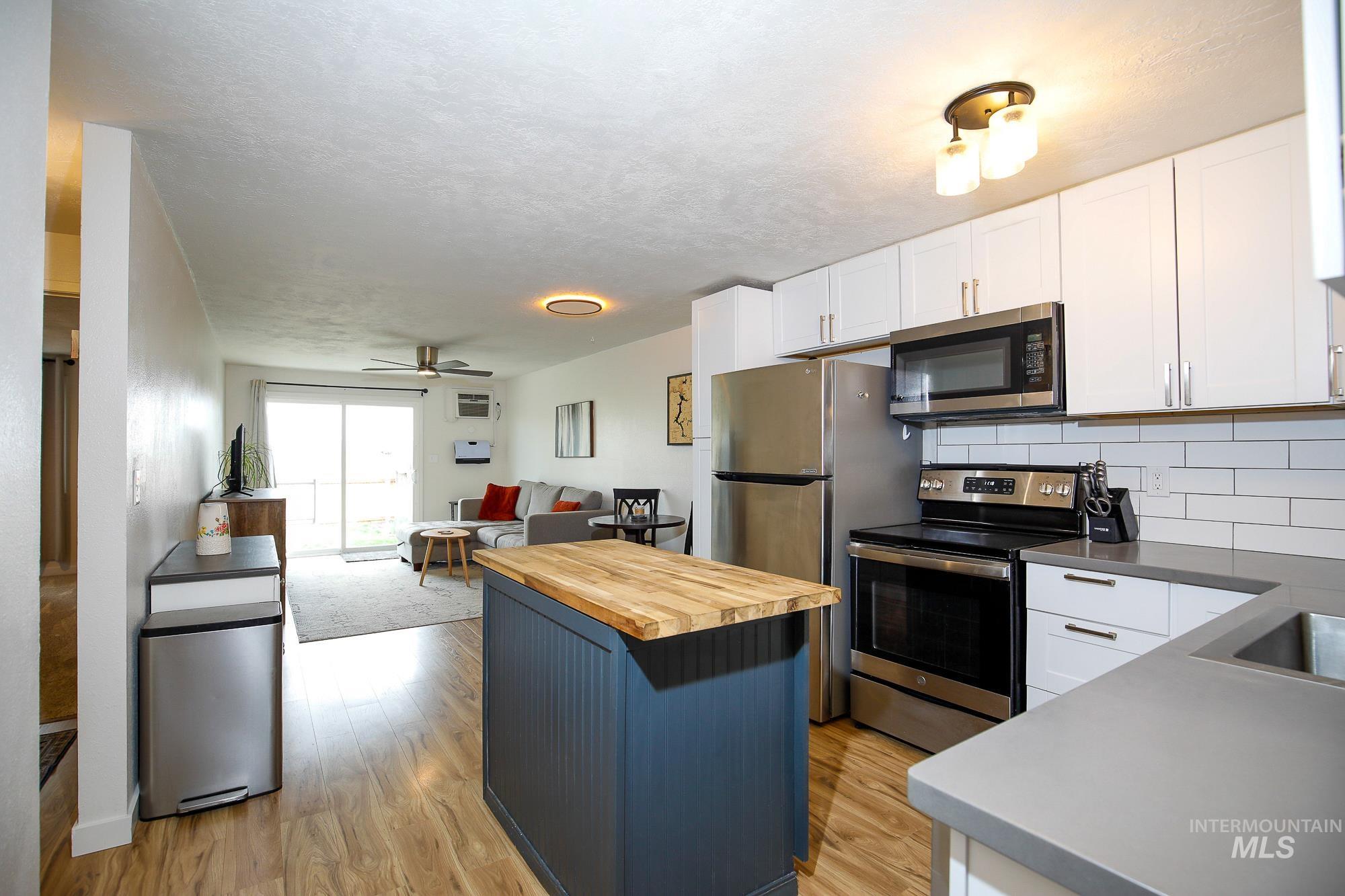 10534 West Fox Ridge Drive Boise, ID 83709 - Photo 15 of 15 Kitchen featuring butcher block counters, a kitchen island, stainless steel appliances, open floor plan, and light wood finished floors