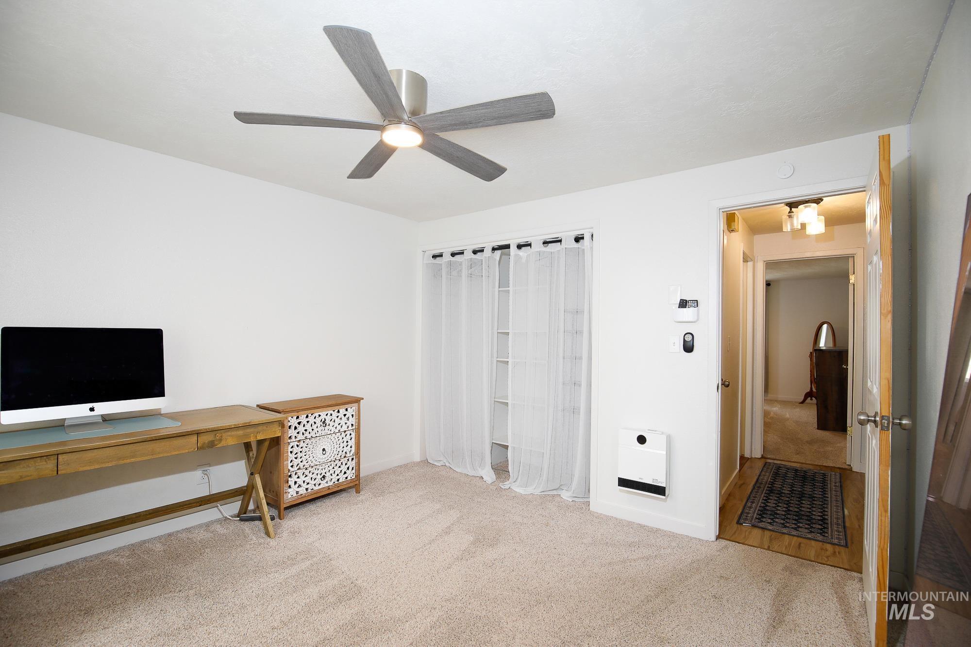 10534 West Fox Ridge Drive Boise, ID 83709 - Photo 4 of 15 Home office with light colored carpet, a ceiling fan, and heating unit