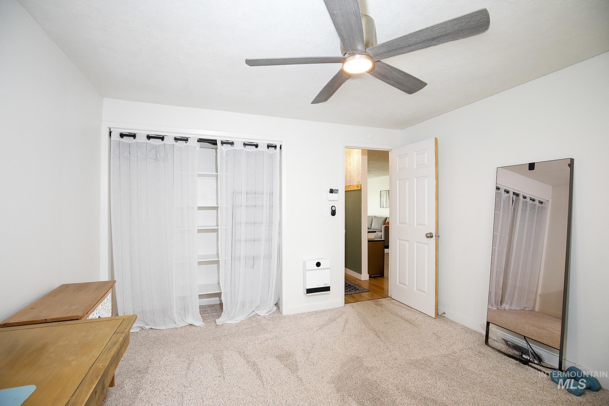 10534 West Fox Ridge Drive Boise, ID 83709 - Photo 5 of 15 Unfurnished bedroom with light colored carpet, ceiling fan, a closet, and heating unit