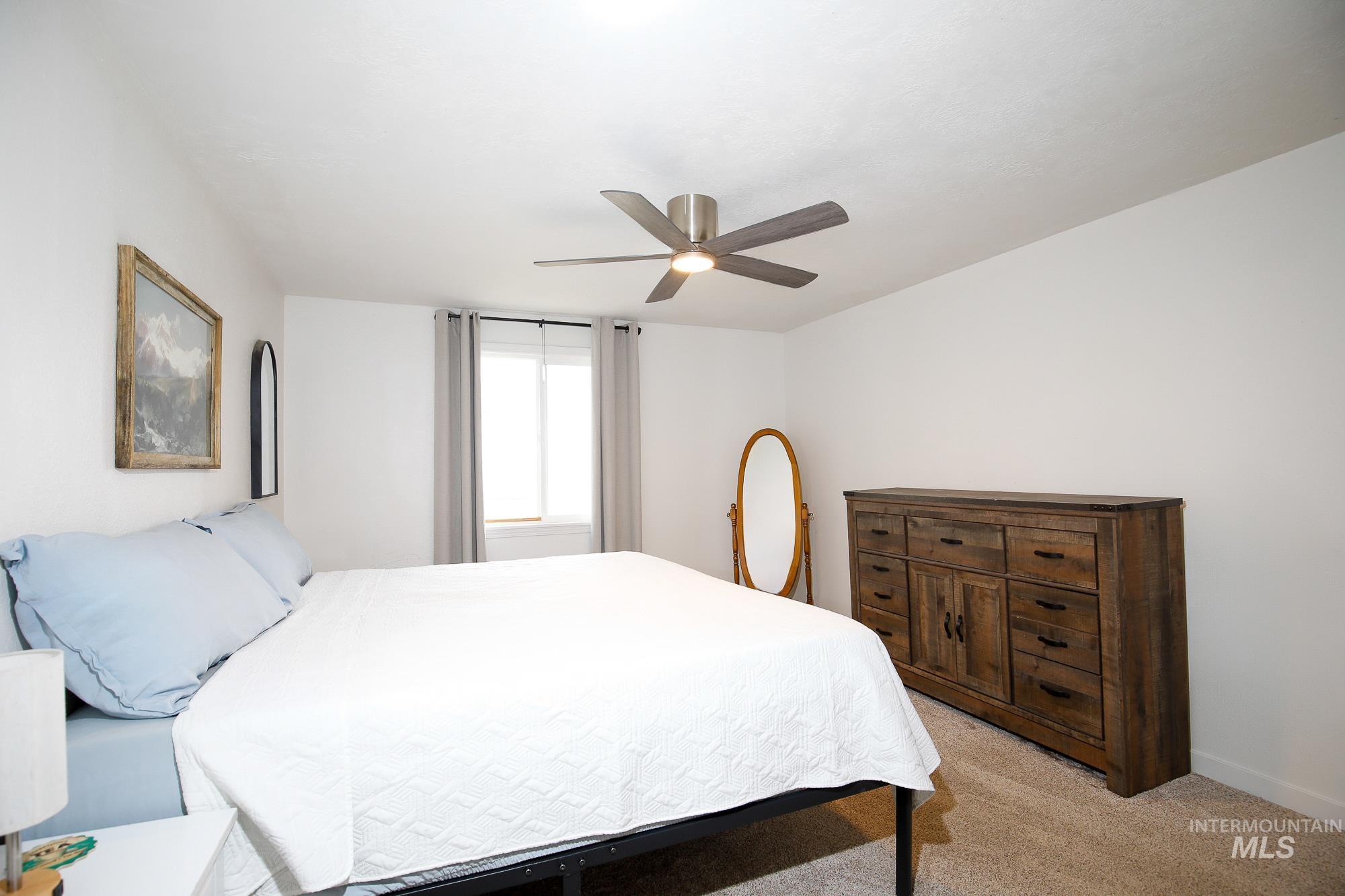 10534 West Fox Ridge Drive Boise, ID 83709 - Photo 8 of 15 Bedroom with light colored carpet and ceiling fan