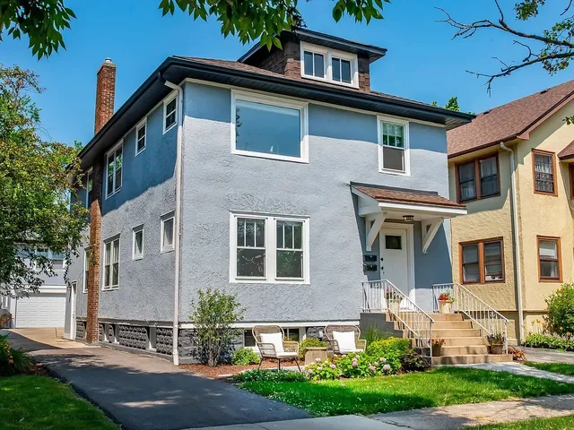 a front view of a house with a yard and trees