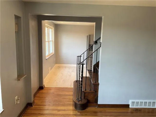 a view of entryway and hall with wooden floor