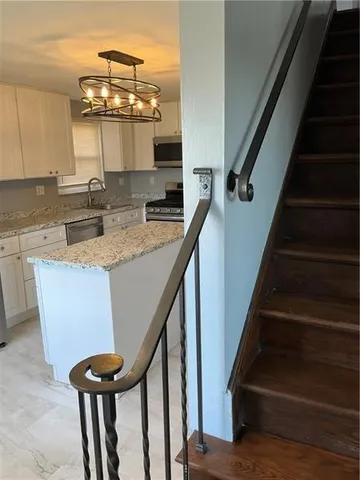 a view of entryway and kitchen with wooden floor