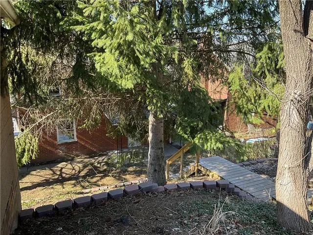 a view of a yard with plants and wooden fence