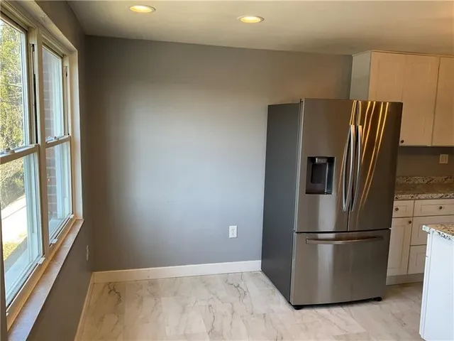 a view of a refrigerator in kitchen and a window