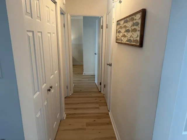 a view of a hallway with wooden floor and entryway
