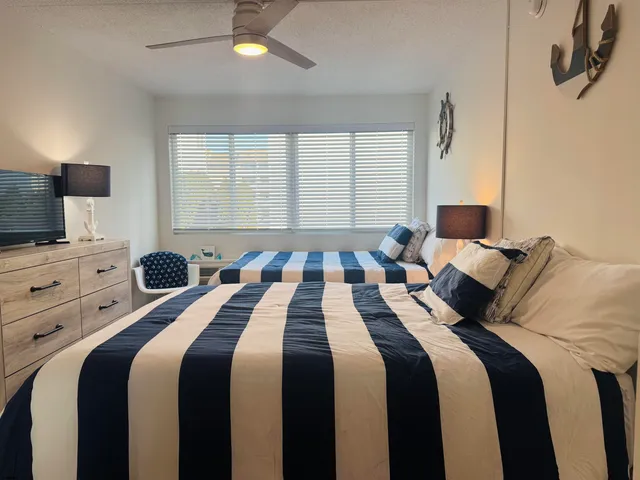a bedroom with a bed and a flat tv screen on the dresser