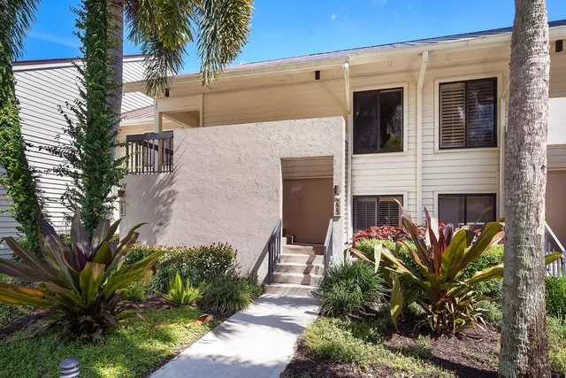 a front view of a house with plants