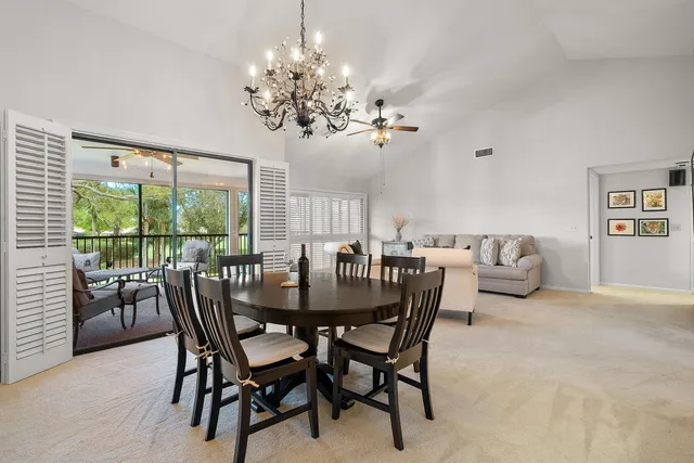 a view of a dining room with furniture a chandelier and wooden floor