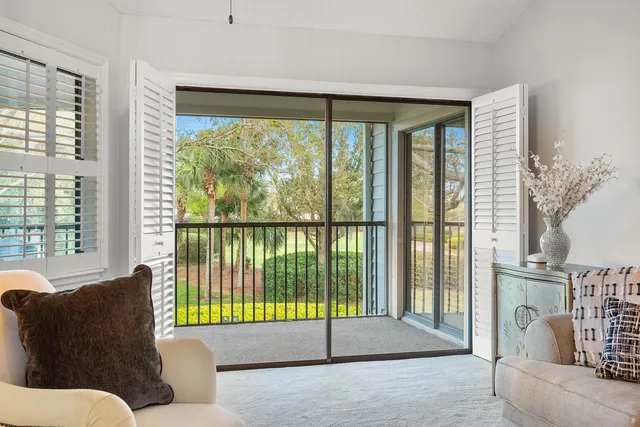 a living room filled with furniture and a glass door