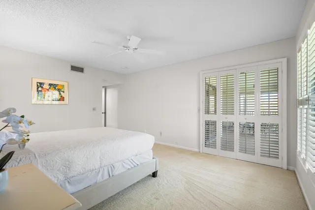 a spacious bedroom with a bed and a large window