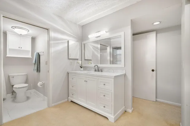 a spacious bathroom with a toilet sink and mirror