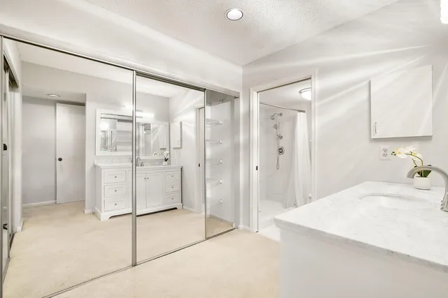 a bathroom with a granite countertop sink mirror and shower
