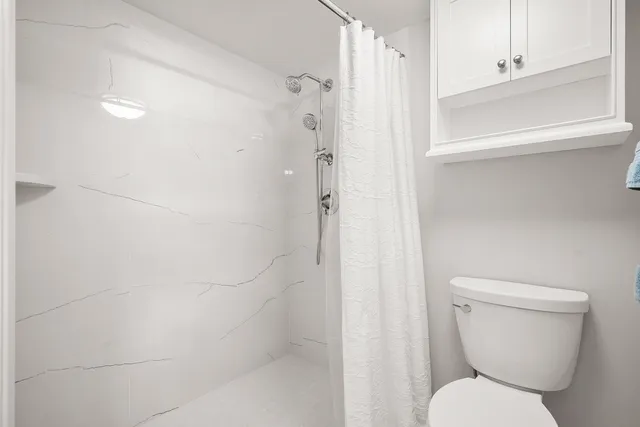 a bathroom with a toilet and shower