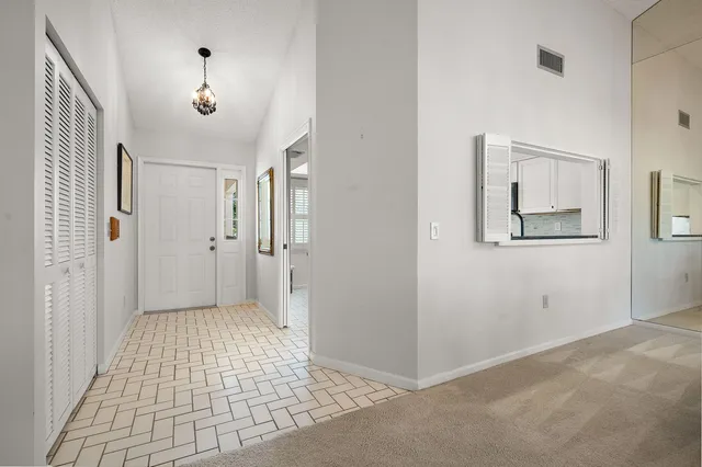 a view of a hallway with wooden floor and a bathroom