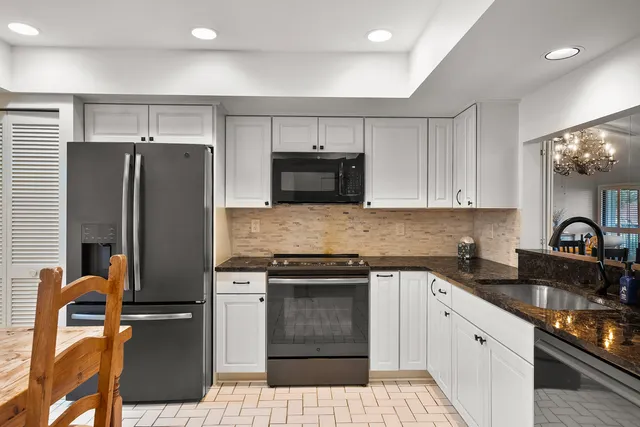 a kitchen with stainless steel appliances granite countertop a refrigerator stove and sink